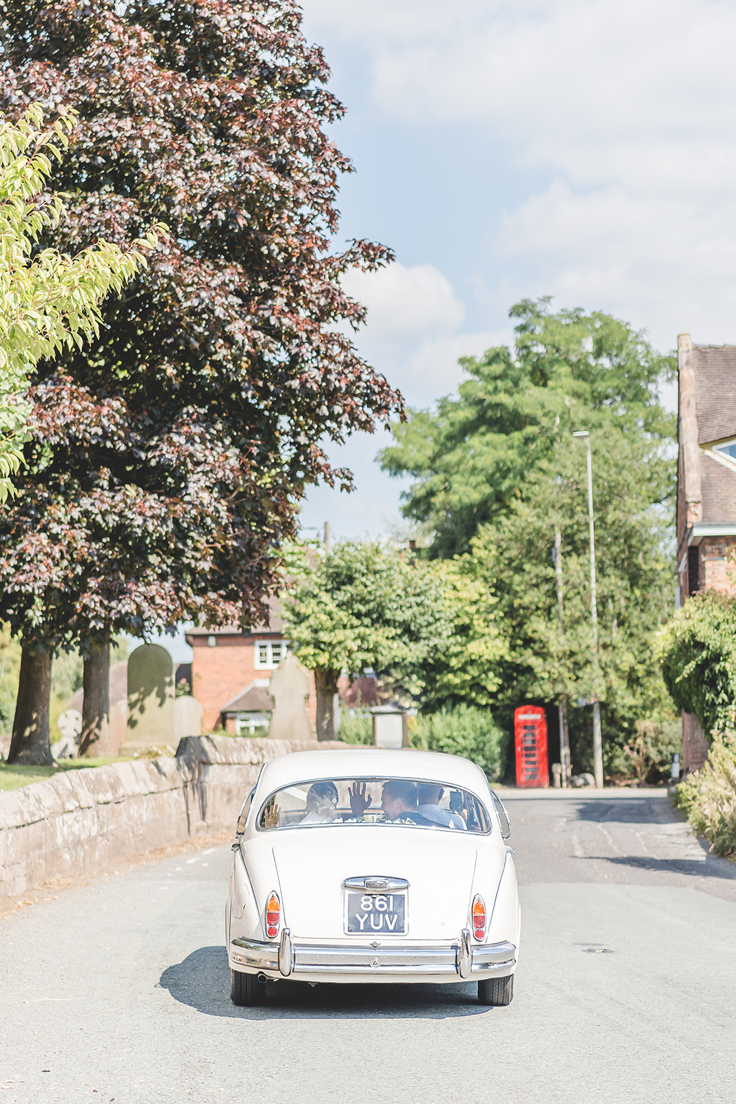 bride and groom drive to nunsmere hall in classic wedding car 