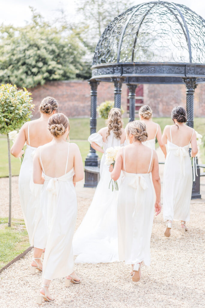 bridesmaids walk across gardens at foxtail