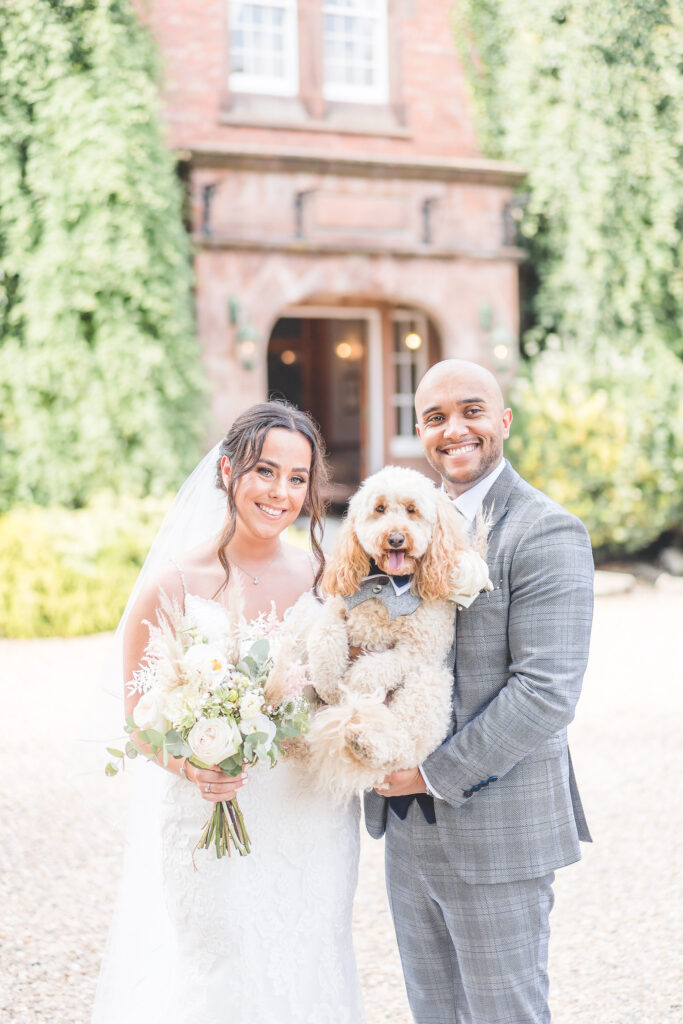 Bride and Groom with dog outside  Nunsmere Hall
