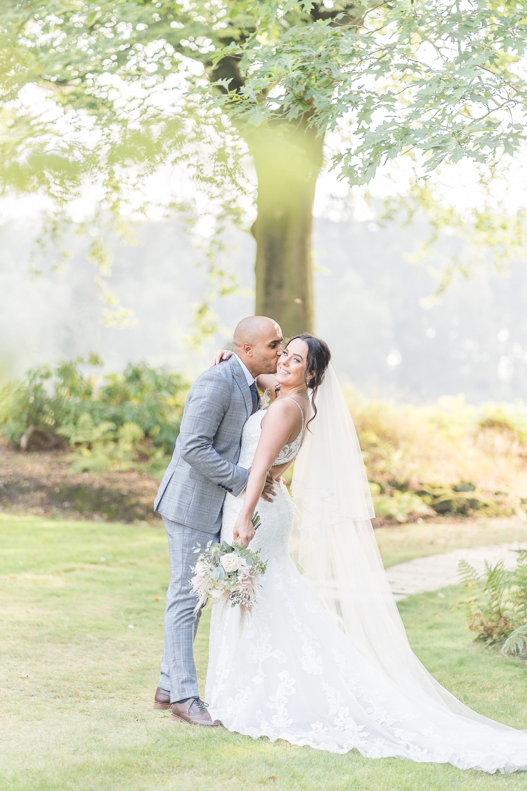 bride and groom kiss in sunshine at Nunsmere Hall 