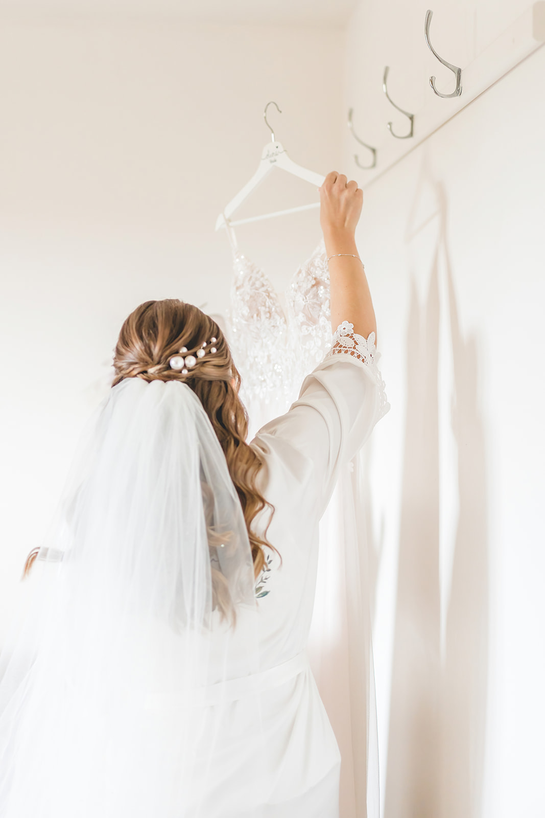bride reaches for wedding gown