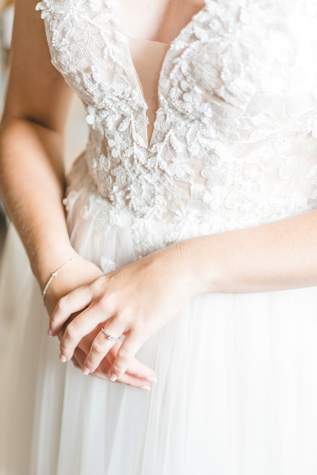 close up of engagement ring and dress details