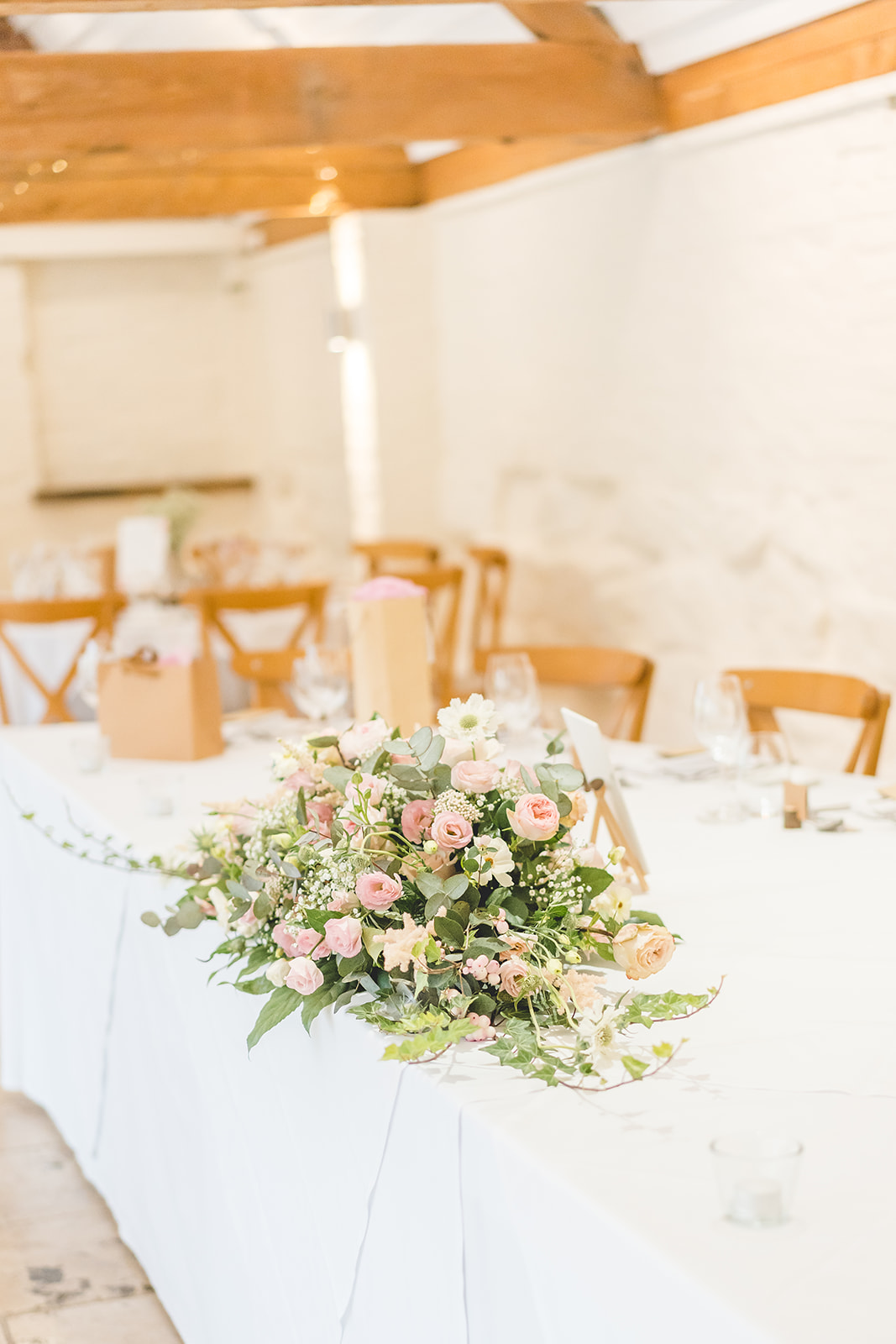 wedding flower arrangement on top table at Curradine Barns 