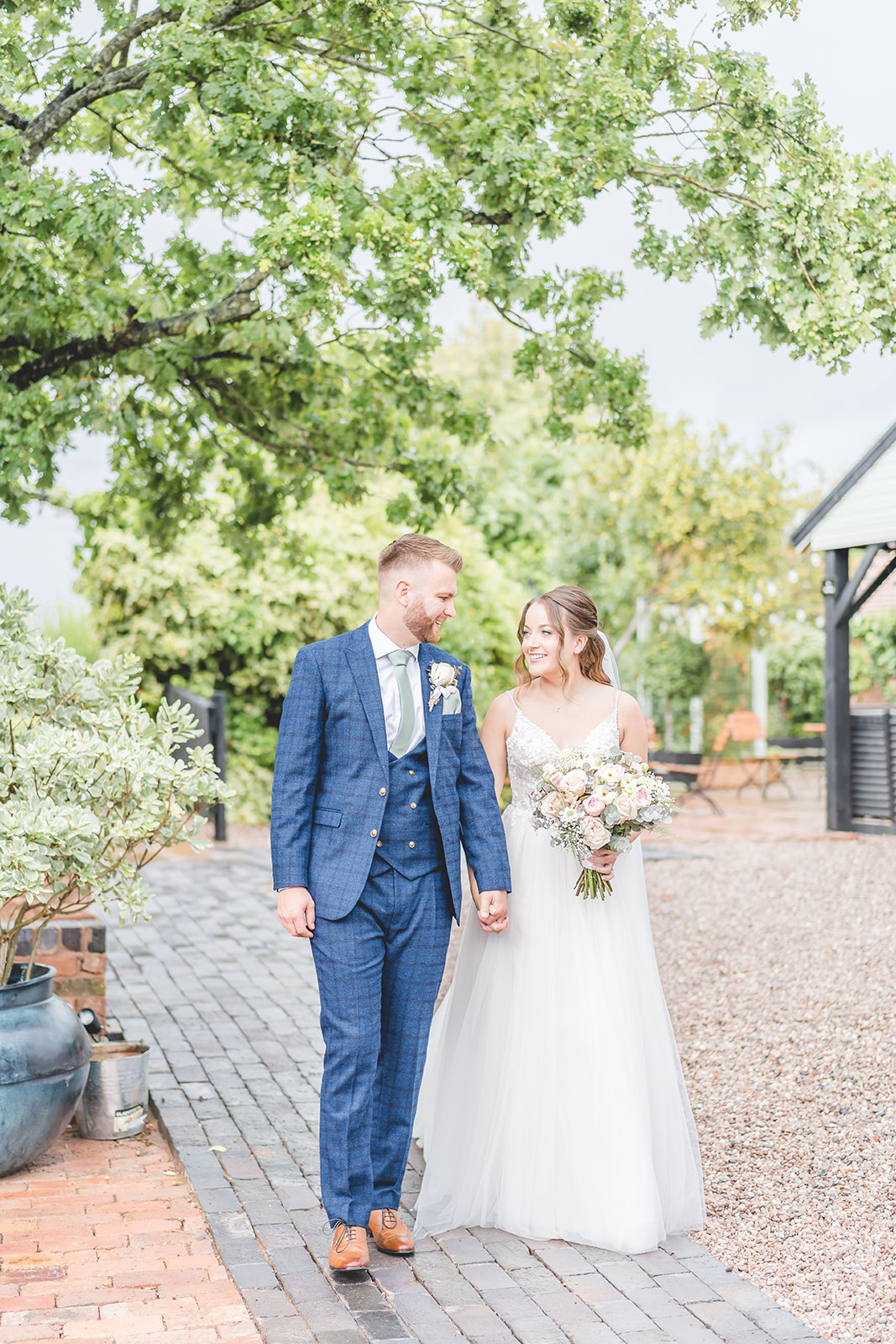 bride and groom walk together at Curradine Barns 