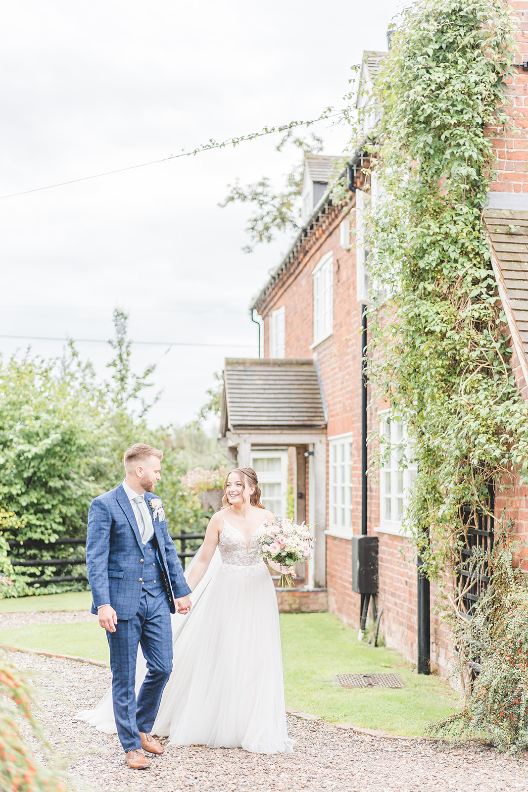 bride and groom walk through venue at Curradine Barns wedding