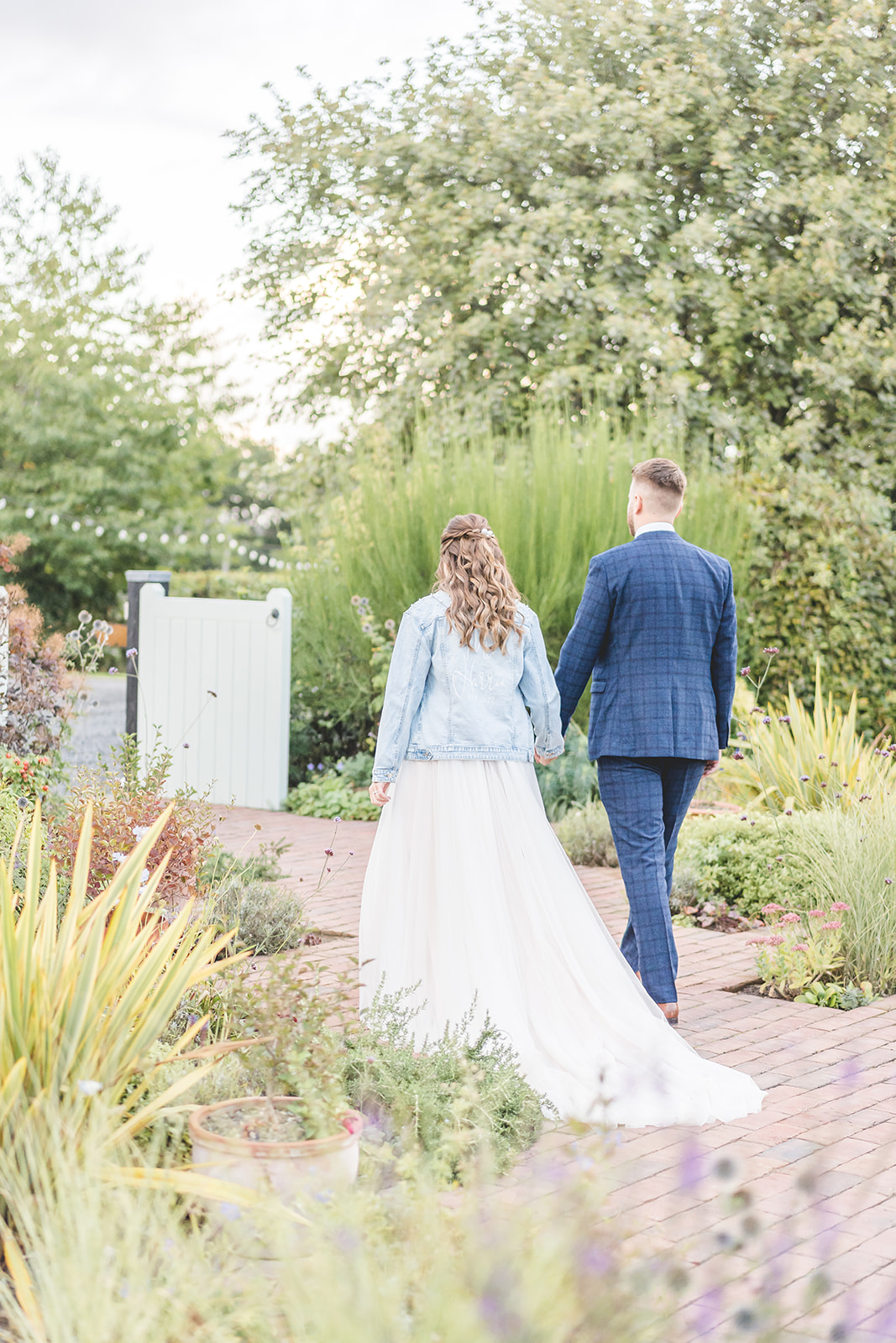 bride and groom walk in denim jacket 
