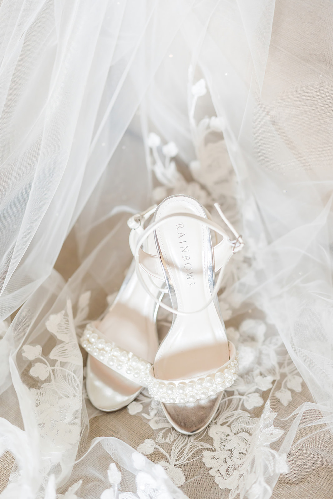 bridal shoes with pearls ontop of veil 