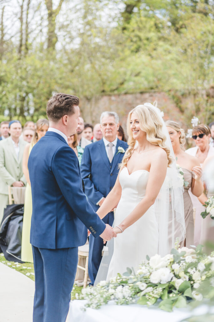 bride and groom smile during outside ceremony at Saltmarshe Hall Wedding