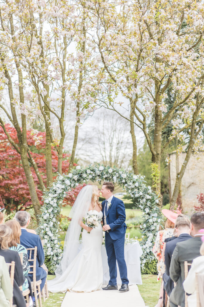 bride and groom kiss under the blossom at Saltmarshe Hall Wedding