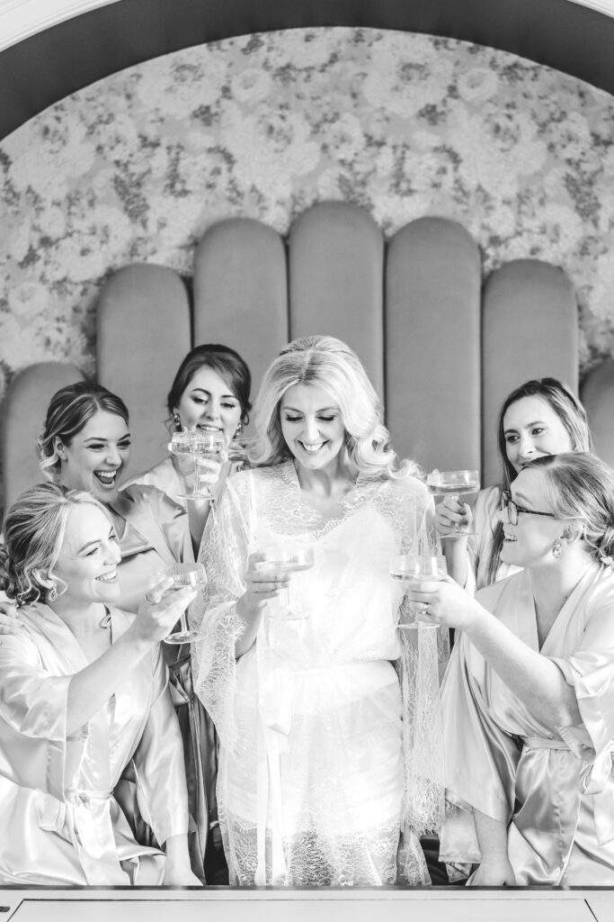 bride and bridesmaids clink glasses at Saltmarshe Hall Wedding