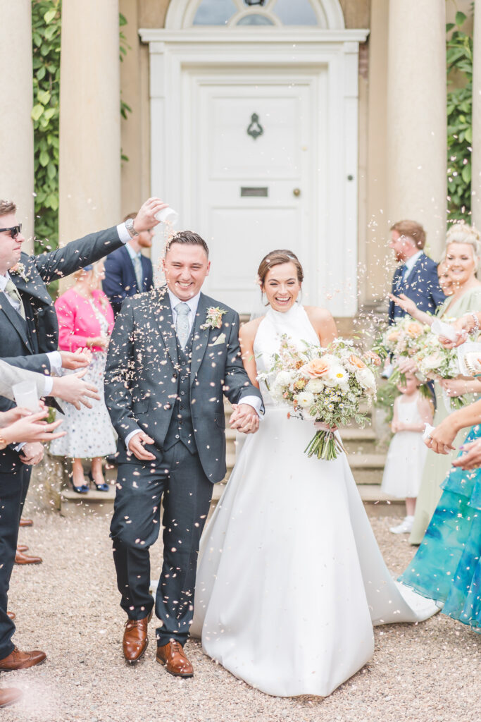 confetti is thrown over the couple at at iscoyd park wedding venue in Shropshire
