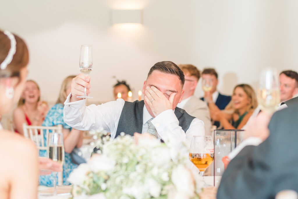 groom raises his glass during the best mans speech at iscoyd park
