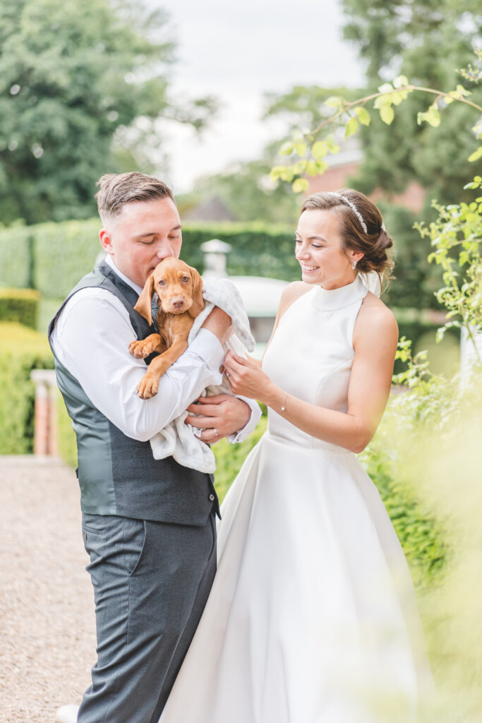 bride and groom are surprised with puppy on their wedding day at iscoyd park 
