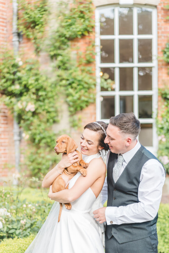 bride and groom are surprised with their puppy on their wedding day at iscoyd park 